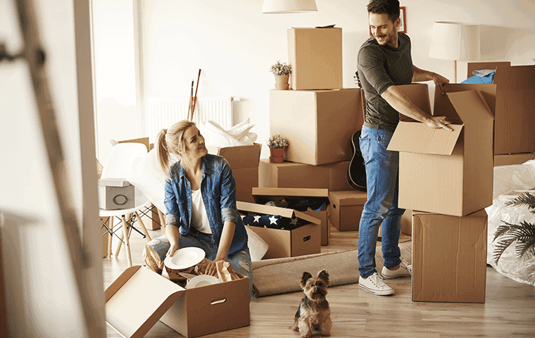 two people with moving boxes moving into apartment