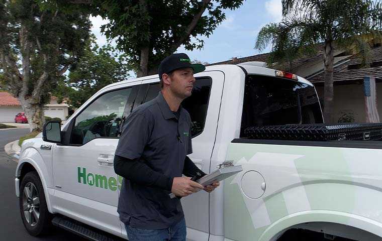 tech in front of a homeshield pest control truck